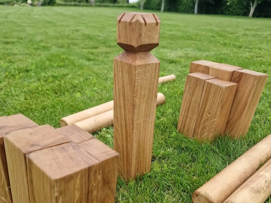 Vikingų žaidimas KUBB ant vejos: karalius ir mediniai blokeliai