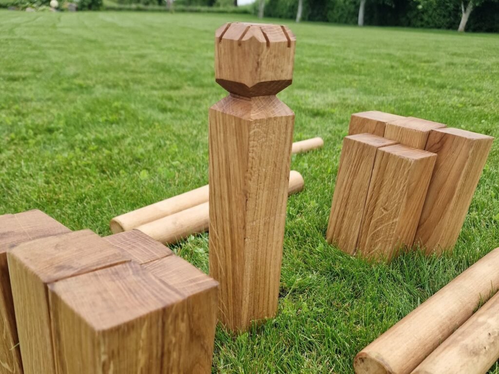 Vikingų žaidimas KUBB ant vejos: karalius, mediniai blokeliai ir lazdelės